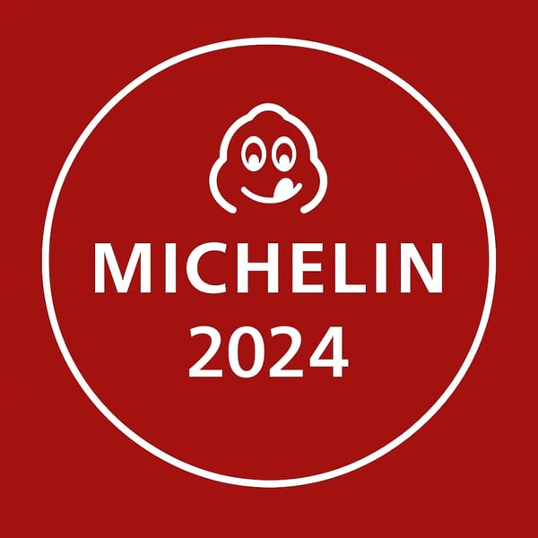 Michelin Guide 2024 award logo with a smiling face on a red background.