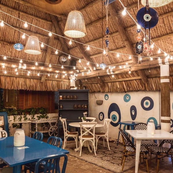 El Turco Turkish Food's dining area with straw roof, string lights, and evil eye decorations.