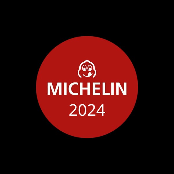 Red Michelin Guide 2024 logo with a smiling chef icon on a black background.