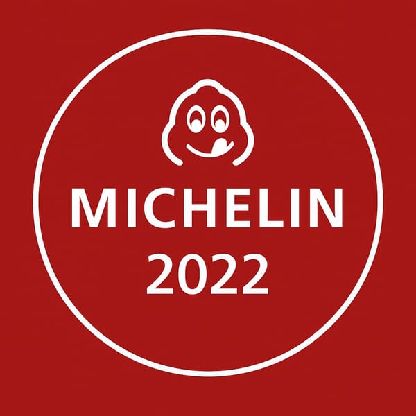 Michelin 2022 award logo with a smiling chef icon on a red background.