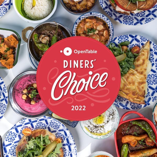 OpenTable Diners' Choice 2022 award over a spread of Turkish dishes including hummus, rice, and pastries.